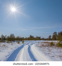 ground road among winter snowbound forest at sunny day - Shutterstock ID 2255444971