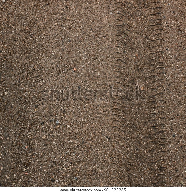 Ground road with\
car wheel marks, square\
image.