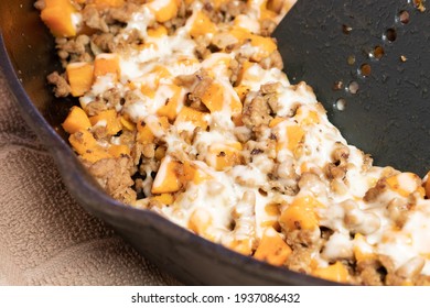 Ground Turkey Meat, Cubed Sweet Potatoes, Melted Mozzarella Cheese, And Diced Onions Served For Dinner In A Cheesy, Nutritious Cast Iron Skillet Meal In A Home Kitchen.