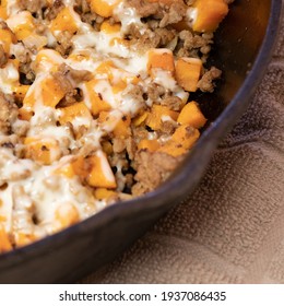 Ground Turkey Meat, Cubed Sweet Potatoes, Melted Mozzarella Cheese, And Diced Onions Served For Dinner In A Cheesy, Nutritious Cast Iron Skillet Meal In A Home Kitchen.