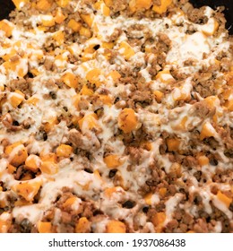 Ground Turkey Meat, Cubed Sweet Potatoes, Melted Mozzarella Cheese, And Diced Onions Served For Dinner In A Cheesy, Nutritious Cast Iron Skillet Meal In A Home Kitchen.