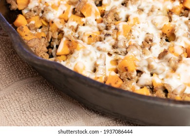 Ground Turkey Meat, Cubed Sweet Potatoes, Melted Mozzarella Cheese, And Diced Onions Served For Dinner In A Cheesy, Nutritious Cast Iron Skillet Meal In A Home Kitchen.