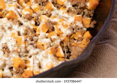 Ground Turkey Meat, Cubed Sweet Potatoes, Melted Mozzarella Cheese, And Diced Onions Served For Dinner In A Cheesy, Nutritious Cast Iron Skillet Meal In A Home Kitchen.