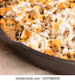 Ground Turkey Meat, Cubed Sweet Potatoes, Melted Mozzarella Cheese, And Diced Onions Served For Dinner In A Cheesy, Nutritious Cast Iron Skillet Meal In A Home Kitchen.