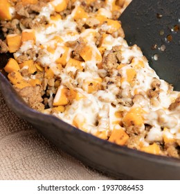 Ground Turkey Meat, Cubed Sweet Potatoes, Melted Mozzarella Cheese, And Diced Onions Served For Dinner In A Cheesy, Nutritious Cast Iron Skillet Meal In A Home Kitchen.