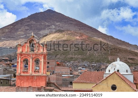 Ground view of the ancient bell tower of San Sebastian church with the Cerro Rico in the background in Potosi, Bolivia. Religious architecture and landscape. Southamerica