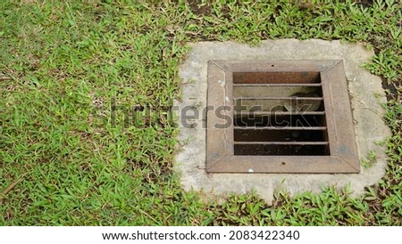 ground water absorption in the garden . water hole with square shape and iron grate covers. 