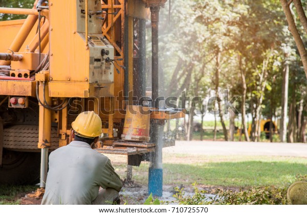 Ground water hole drilling machine\
installed on the old truck in Thailand. Worker keeping an eye on\
Ground water well drilling. Ground water well\
drilling.