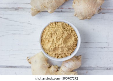 Grounded ginger and ginger root on white wooden surface. - Powered by Shutterstock