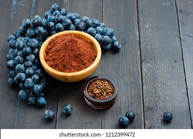 Grounded Grape Seed Grist And Fruits, Seeds On Black Wood Table