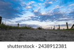 A ground-level perspective captures a country road leading into a vivid evening sky, adorned with a dramatic cloudscape. Dramatic Cloudscape from Ground Level Along a Country Road. High quality photo