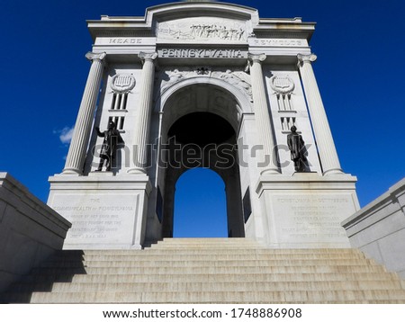 Ground-level shot of a large monument at Gettysburg, Pennsylvania with a dark blue sky behind it.