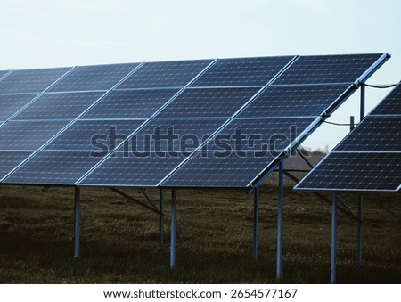 Ground-mounted solar panel array, crystalline silicon panels angled to maximize sun exposure. Renewable energy, sustainable technology, and environmentally conscious infrastructure.