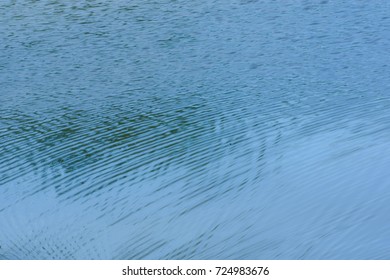 Grounds on the surface of the water flow from the flow of water to converge. The wind blows until a small wave. Reflect sunrise and shade from trees. Beautiful pattern Like art from nature
