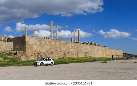 The grounds of Persepolis, Achaemenid soldiers carved on the rock, the lion and bull battle, the throne of Xerxes, tourists visiting Persepolis at sunset
