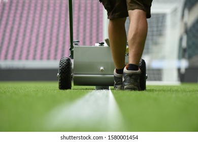 Groundskeeper pulls chalk lines on the field