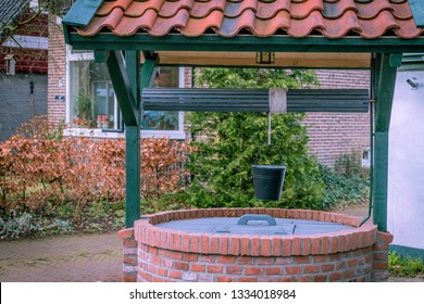 Groundwater Well, Artesian Aquifer With The Ancient Brick Wall In The Garden.