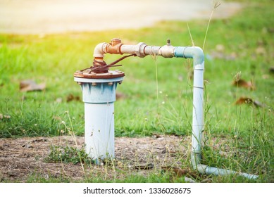 Groundwater Well With Pvc Pipe And System Electric Deep Well Submersible Pump Water On Green Meadow / Groundwater Testing And Sampling Pollution Concept