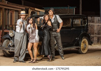 Group Of 1920s Vintage Gangsters Outside Aiming Weapons