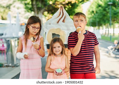 Group Of 3 Funny Kids Eating Ice Cream Outdoors On A Nice Sunny Day