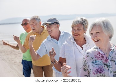 group of 5 seniors at the sea play happily making the "ok" sign with their finger - Shutterstock ID 2238188531