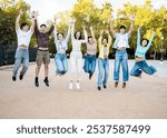 A group of 8 young people of different ethnicities between 18 and 25 years old have fun in the street at sunset.Millennials are jumping in a park at the same time.Concept of youth groups.