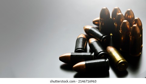Group of 9mm pistol bullets on gray background, soft and selective focus on black bullets butts.
