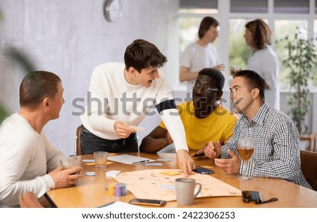 Group of active men play board games during a friendly meeting