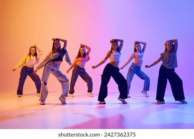 Group of active people, talented dancing hip hop against gradient studio background in neon light. Contemp. Concept of hobby, youth, childhood, style, fashion, dance school - Powered by Shutterstock