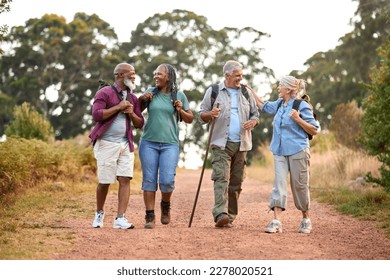 Group Of Active Senior Friends Enjoying Hiking Through Countryside Walking Along Track Together - Powered by Shutterstock