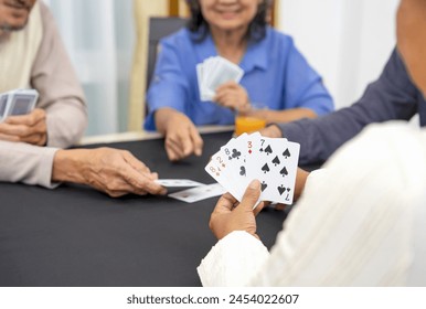 group of active senior pensioners playing cards game together, concept elderly retired people entertainment,recreation,encourages social interaction,help memory retention  - Powered by Shutterstock