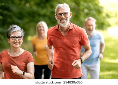 Group of active senior people running together outdoors in park, smiling sporty mature men and women having cardio training outside, jogging on nature, enjoying healthy active liefstyle on retirement - Powered by Shutterstock