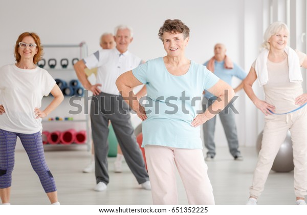 Group of\
active seniors exercising in fitness\
club