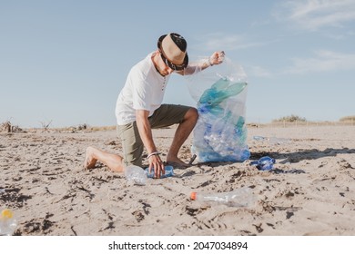 Group Of Activist Friends Collecting Plastic Waste On The Beach. People Cleaning The Beach, With Bags. Concept Of Environmental Conservation And Ocean Pollution Problems