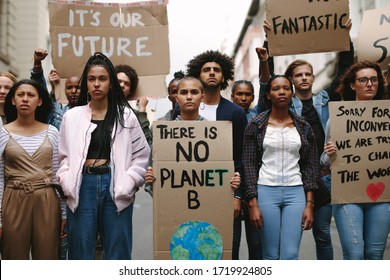 Group of activists with banners protesting to save earth. Men and women rebellions doing a silent protest over global warming and pollution. - Powered by Shutterstock