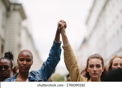 Group of activists with holding hands protesting in the city. Rebellions doing demonstration on the street holding hands. - Shutterstock ID 1700390182