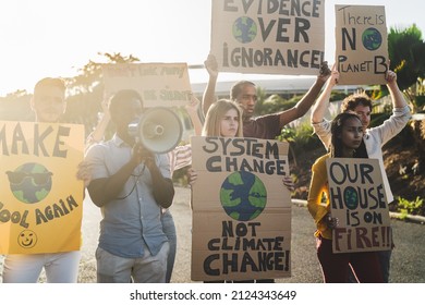 Group of activists protesting for climate change - Multiracial people fighting on road holding banners over environments disasters - Global warming concept