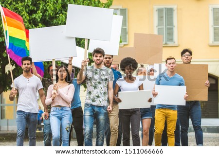 Group of activists is protesting outdoors - Crowd demonstrating against unemployment, taxes, wages dumping and other political and social issues, white signboards for any concepts