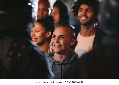Group of activists protesting silently standing in front of policemen and smiling. Woman looking at the policeman and smiling during a demonstration.