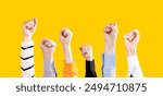 Group of activists raising their fists in the air. People with raised fists front on yellow background. Mixed group of men and women