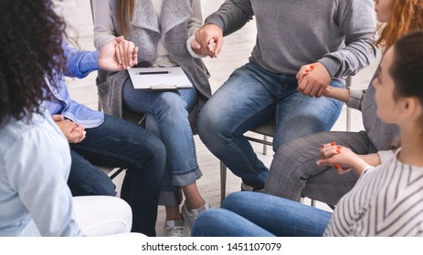 Group of addicted people holding hands, sitting in circle of trust at therapy session, panorama