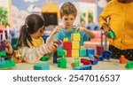 Group of Adorable Creative Kids Using Colorful Building Blocks to Play Together. Cheerful Female Teacher Spending Productive Time in Daycare, Teaching Multiethnic Kids in Preschool