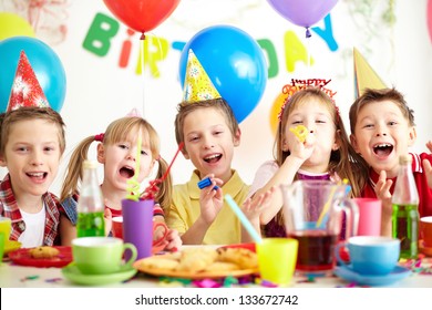 Group Of Adorable Kids Having Fun By Festive Table At Birthday Party