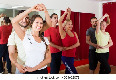 Group of adult american people dancing salsa in studio