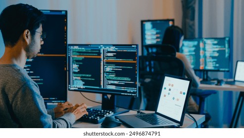 Group Adult Asia male, female freelance typing write prompt AI bot IT app smart program nomad, video game, terminal with coding language, designer, big data center on desktop computer in night office. - Powered by Shutterstock