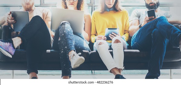 Group Adult Hipsters Friends Sitting Sofa Using Modern Gadgets.Business Startup Friendship Teamwork Concept.Creative People Working Together Sale Project.Coworking Process Office Studio.Blurred Wide