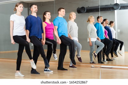 Group Of Adult People Lining Up While Fulfilling Dance Movements Of Folk Celtic Dance In Choreography Class