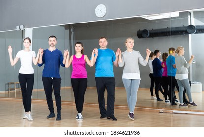 Group Of Adult People Lining Up While Fulfilling Dance Movements Of Folk Celtic Dance In Choreography Class