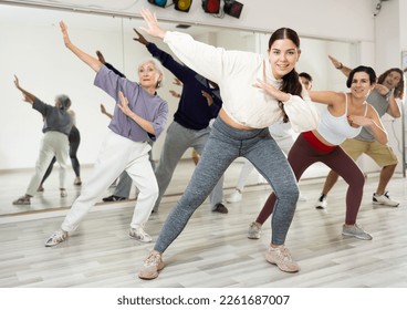 Group of adult people practices dance aerobics in class in the dance studio - Powered by Shutterstock