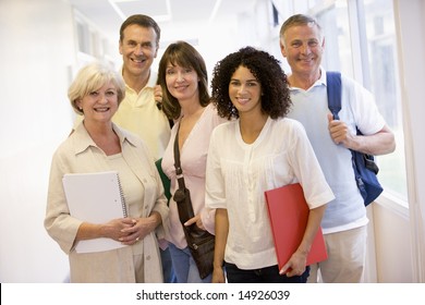 A group of adult students with backpacks standing in a campus corridor - Powered by Shutterstock